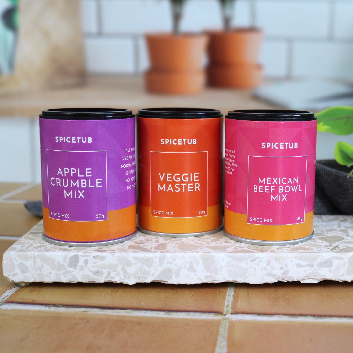 Three Spicetub mixes on a stone slab with plants in the background