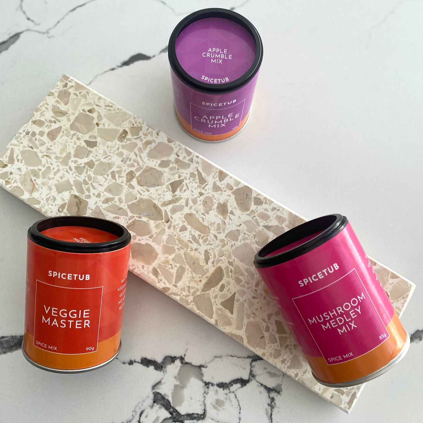 Three Spicetub containers on a marble surface