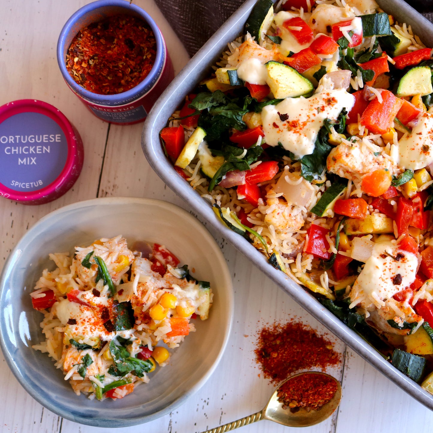 Portuguese chicken mix seasoning container with a dish of vegetable and rice casserole on a wooden surface.