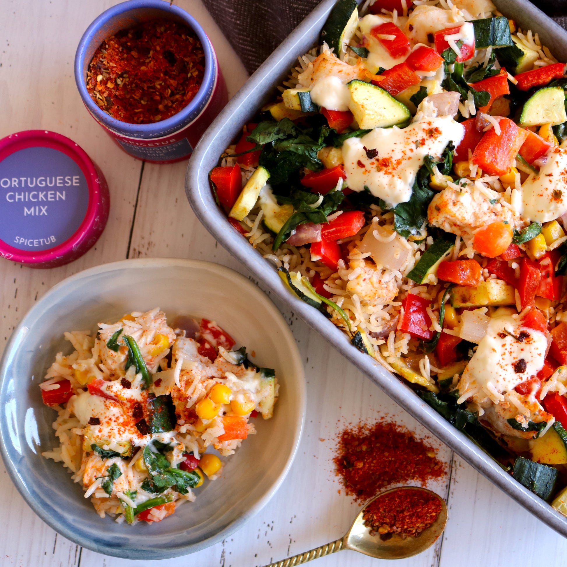 Portuguese chicken mix seasoning container with a dish of vegetable and rice casserole on a wooden surface.